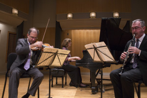 Eye-level view of seated musicians, each playing off of music stands